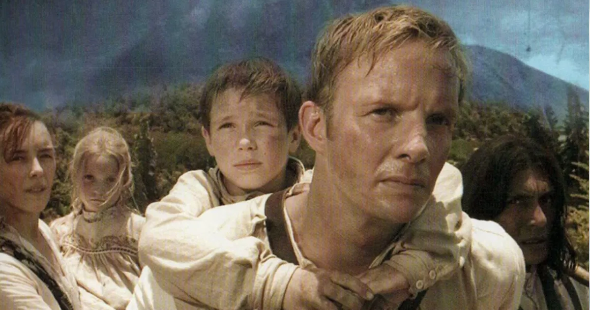 A shot from the movie Krakatoa - shows a man carrying a child away from the volcano.