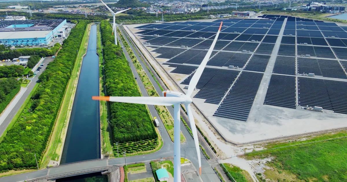 An image showing solar panels and a wind turbine