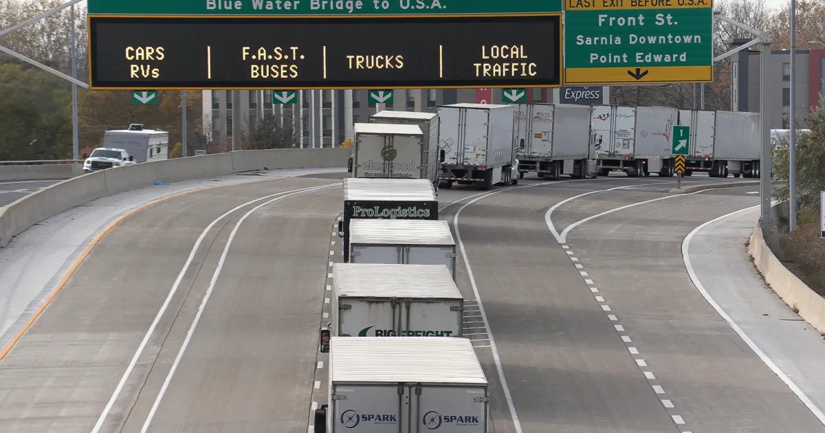 A photo of trucks backed up on the highway.